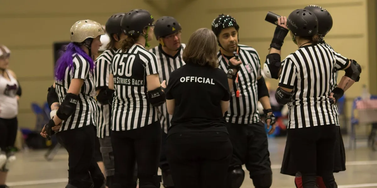 A group of LCRD skating and non-skating officials meeting during a bout
