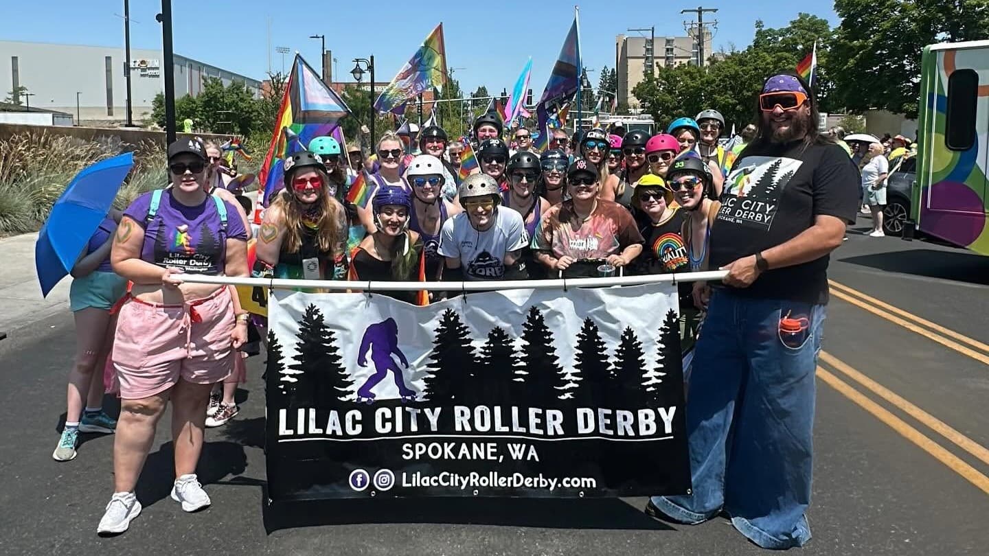 Lilac City Roller Derby members carrying the league banner at Spokane Pride